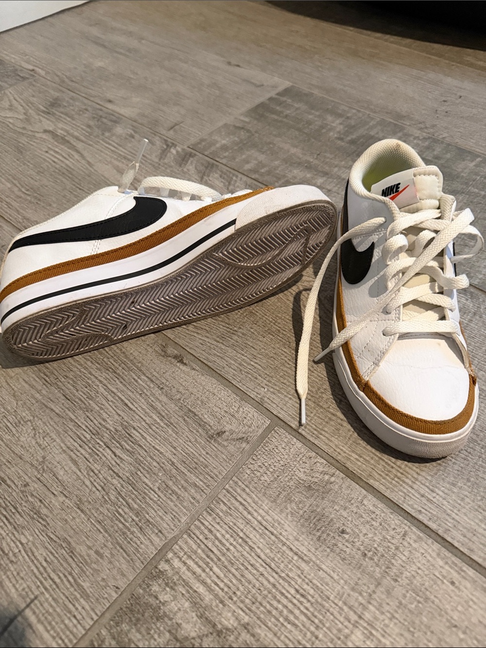 Nike White Low-Top Sneakers with Black Swoosh and Brown Accent